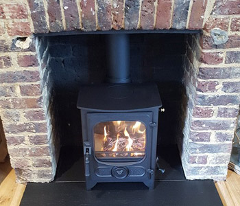 Charnwood Country 4 Woodburner - in black with riven slate hearth. Installed in Peaslake near Guildford, Surrey